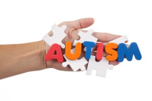 The word AUTISM spelled out over blank puzzle in a hand.